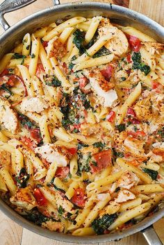 pasta with chicken, tomatoes and spinach in a pan