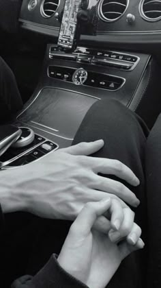 two hands on the steering wheel of a car, one holding the other's hand