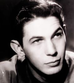 a black and white photo of a man with short hair wearing a collared shirt