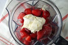 strawberries and ice cream in a blender on top of a napkin with a knife