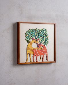 a painting on the wall with two animals and a tree in the middle is shown