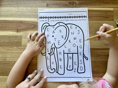 two children are drawing an elephant on a piece of paper