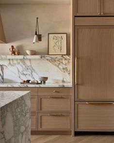 a kitchen with marble counter tops and wooden cabinets