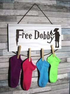 three pairs of socks hanging on a clothes line with a sign that says free dobby