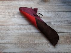 a red and brown tie laying on top of a wooden floor