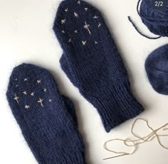 the mitts are blue and have gold stars on them, along with two balls of yarn