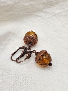 Just in time for fall fashion!! These adorable acorn earrings are the perfect addition to your fall / autumn jewelry collection.D E T A I L S - Style: Acorn Earrings - Earring Length: 1.25 inches (including ear wires) - Bead size: Acorn is 12mm - 1.6cm - 5/8in. - Material: Antique brass or antique copper, copper is shown in photo four. - If you prefer lever back ear wires, I have those available as well and will change them for no additional cost, also shown in last photo.Create a beautiful fall Acorn Jewelry, Acorn Earrings, Woodland Earrings, Autumn Jewelry, Acorn Necklace, Rustic Earrings, Fall Earrings, Jewel Box, Fall Jewelry