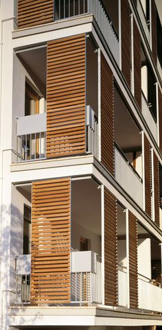 an apartment building with multiple balconies and wooden shutters