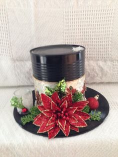 a christmas hat with poinsettis and holly on it sitting on a table