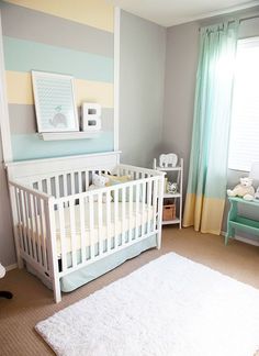 a white crib in a baby's room with blue, yellow and gray walls