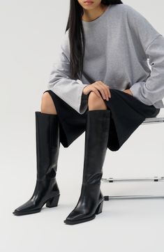 Elevate cool-weather ensembles with this knee-high boot highlighted by a Western-inspired stacked heel and square toe. 2 1/4" heel 17 1/4" shaft Pull-on style Leather upper and lining/synthetic sole Imported Women's Shoes Sleek Knee-high Boots With Stacked Heel And Square Toe, Vagabond Knee High Boots, Sleek Calf Leather Knee-high Boots With Square Toe, Boots 2024 Trend, Vagabond Alina Boots, Mid Calf Boots Outfit, Black Knee-high Boots With Sculpted Heel And Wide Calf, Black Knee-high Calf Leather Boots With Sculpted Heel