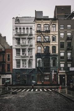 an empty city street with buildings in the background