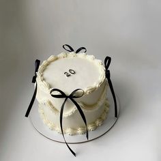 a white cake with black ribbon on top