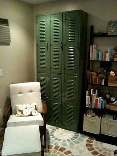 a room with a chair, bookshelf and bookcases in the corner