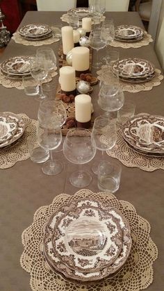 the table is set with dishes and candles