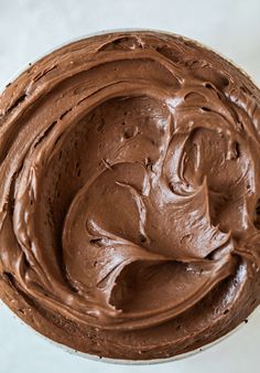 a chocolate frosted cake sitting on top of a white plate