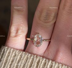 a woman's hand with a diamond ring on top of her finger, showing the inside