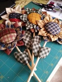 several different types of fabric flowers on a cutting board