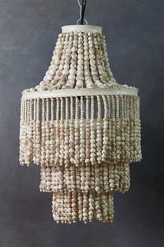 a chandelier made out of beads hanging from a hook on a wall in a room