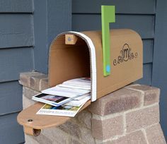 a mailbox is open on the side of a house with newspapers sticking out of it