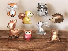 a group of small animal figurines sitting on top of a wooden table next to a wall