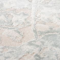 an area rug with white and grey designs on the carpet, closeup view from above