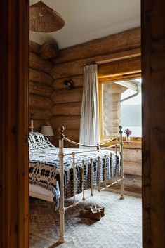 a bed in a room with wooden walls and flooring next to a large window