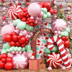 a christmas scene with balloons, candy canes and other holiday decorations in front of a brick wall