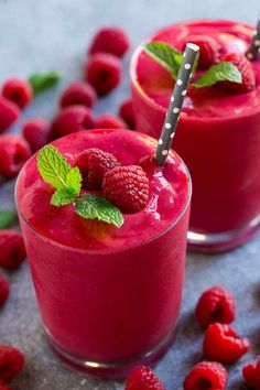 two glasses filled with raspberry smoothie and garnished with mint