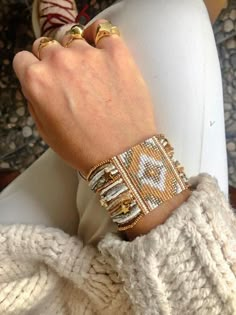 a close up of a person's hand wearing two different bracelets