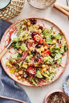 a salad with lettuce, chickpeas and tomatoes