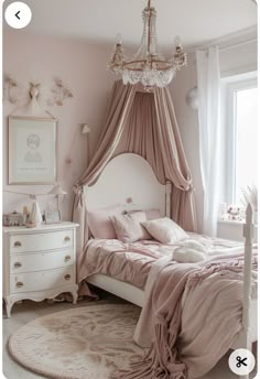 a bedroom with a bed, dresser and chandelier hanging from the ceiling in front of a window