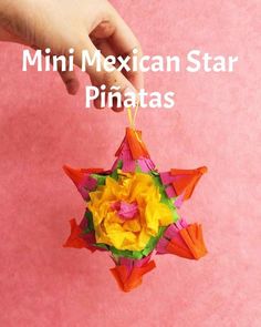 a hand is holding a pinata that looks like a star