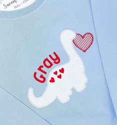 a blue shirt with an elephant and heart appliqued on the chest that says grey