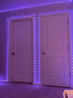 two white doors with purple lights on the wall and carpeted floor in front of them