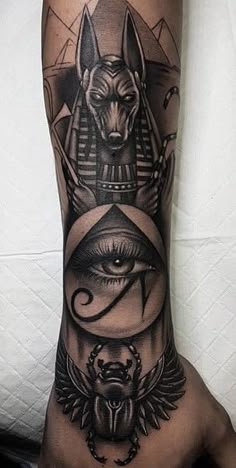 an arm tattoo with egyptian symbols on it and the eye of horush in the center