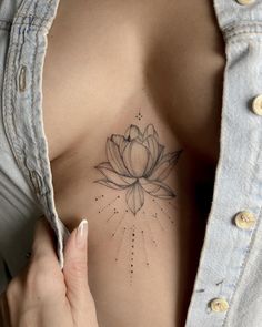 a woman's stomach with a flower tattoo on her chest and the words lotus above it