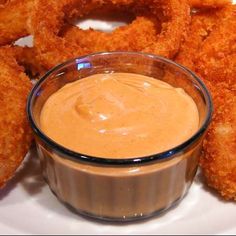 onion rings with dipping sauce in a glass bowl