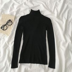 Basic ribbed knit turtleneck long sleeved shirt. Stretches to fit. One size fits S-L 27"-37" chest 21.5" length Classic Black Turtleneck For Fall, Black Classic Turtleneck, Black Classic Funnel Neck Turtleneck, Black High Neck Classic Top, Classic Black High Neck Top, Classic High Neck Black Top, Classic Black Turtleneck Sweater, Ribbed Slim Fit Tops For Fall, Classic High Stretch Black Top