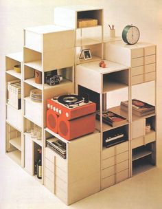 a record player sitting on top of a shelf next to a clock and other items