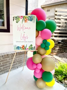 a welcome sign and balloon arch in front of a house