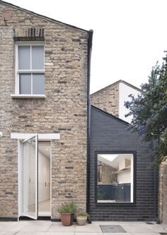 a brick house with an open door and large windows