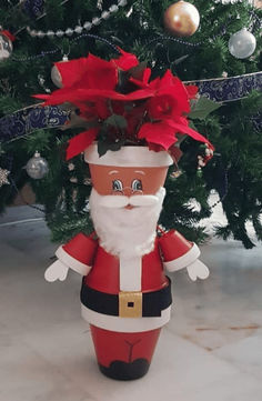 a christmas decoration with a santa clause and poinsettis on it's head