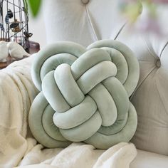 a white couch with a green pillow on top of it