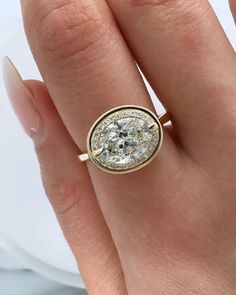 a woman's hand with a ring on it and a diamond in the middle