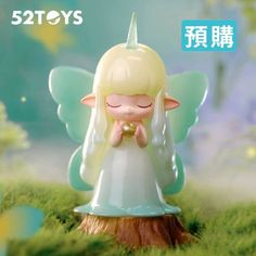 a little angel figurine sitting on top of a tree stump in the grass