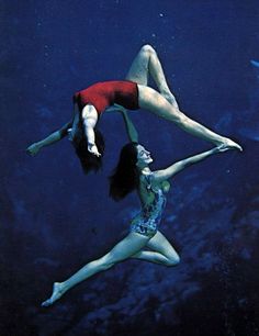 two women are floating in the water with their legs spread out and one is upside down