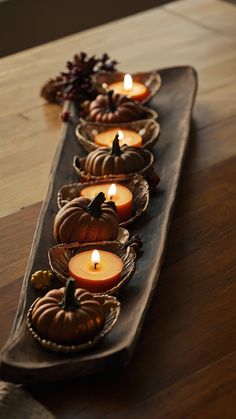 a long wooden tray filled with lots of candles