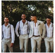 a group of men standing next to each other wearing white shirts and suspender ties