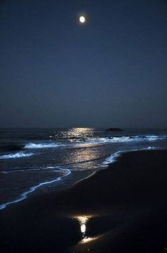 the moon shines brightly in the dark night sky over the ocean with waves crashing on it